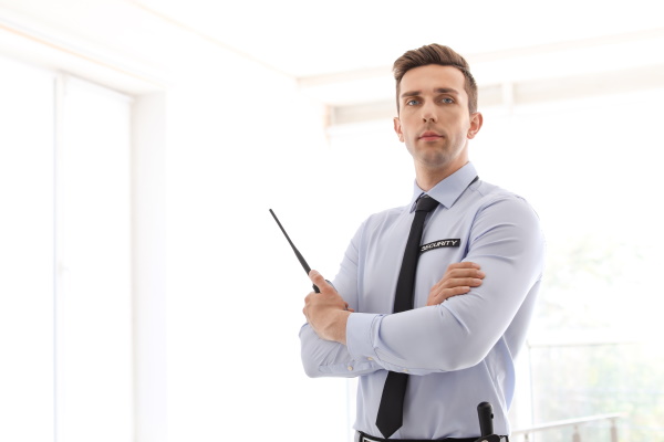 Male security guard with portable radio transmitter indoors